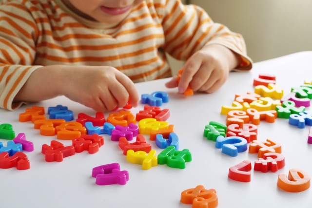 ひらがなの玩具で遊ぶ子供